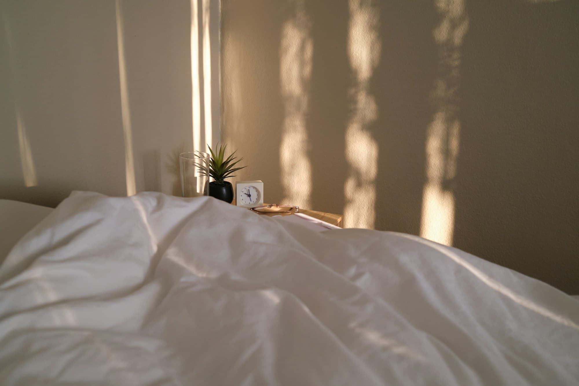 Une chambre calme et lumineuse, lumière du matin filtrant à travers les rideaux.