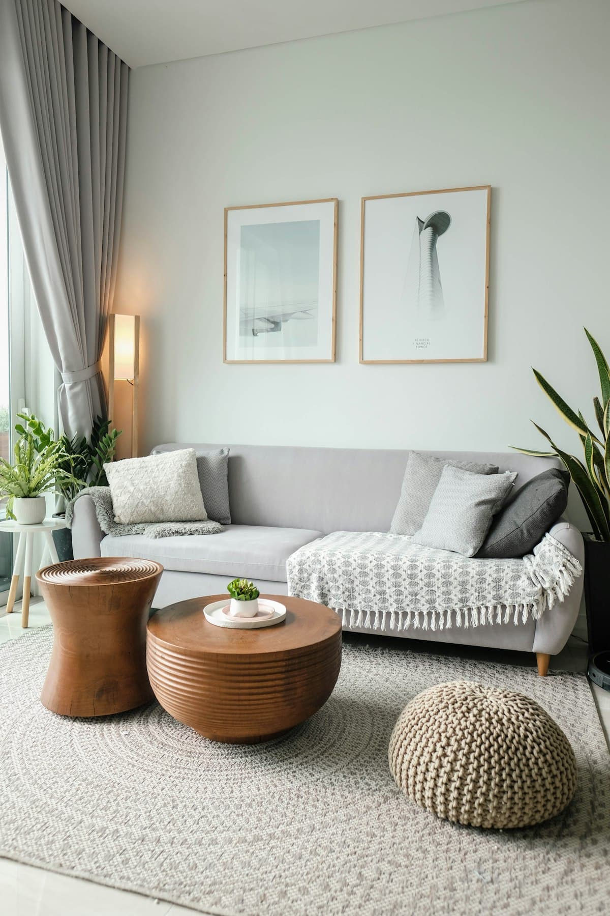 Un salon propre et bien rangé dans son ensemble : canapé, tables basses et tapis, du sol au plafond.